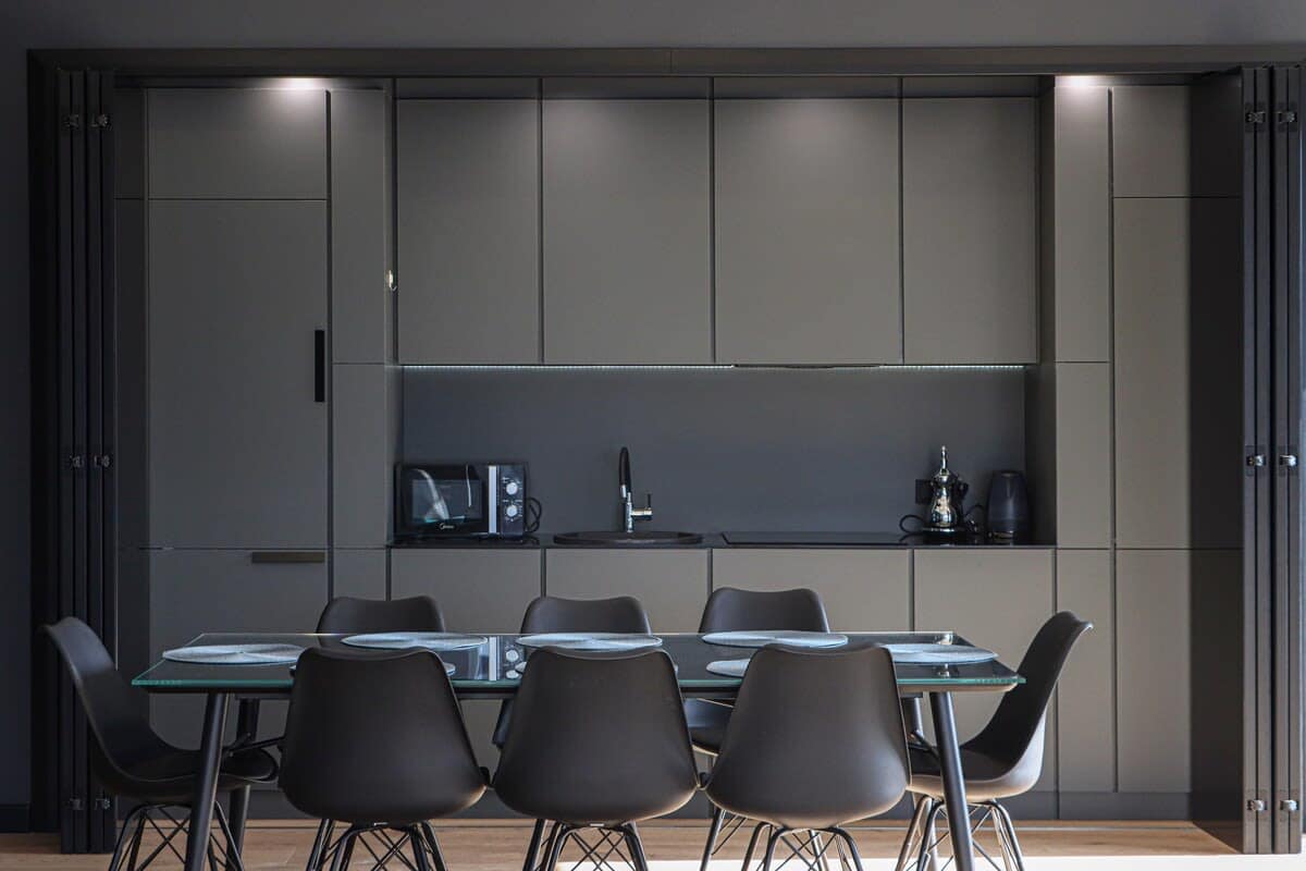 The kitchen features a modern and clean design, complete with a dining table that seats eight people.