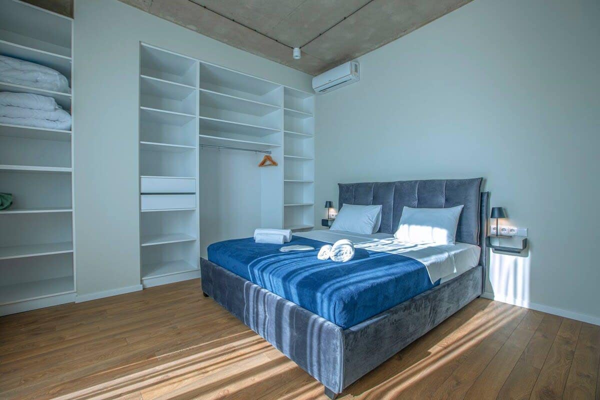 Bright double bed bedroom with spacious wardrobe and bedside lamps