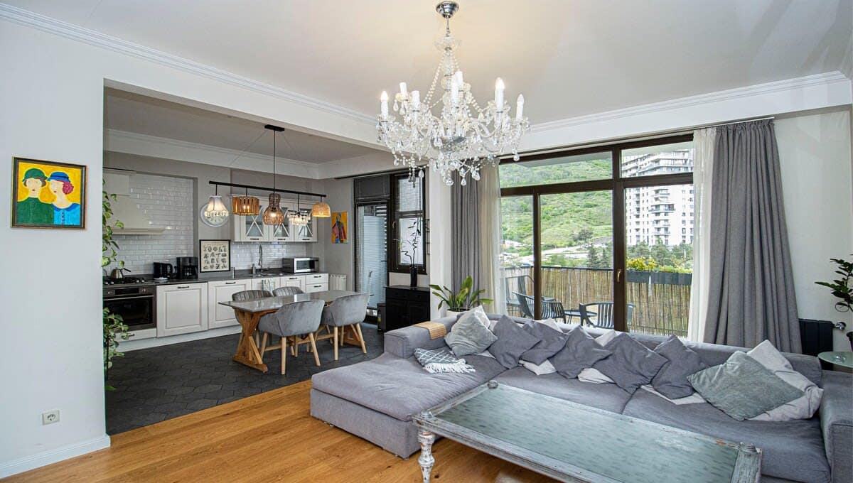 The apartment is spacious with large windows and a balcony, allowing you to enjoy the beautiful greenery outside.