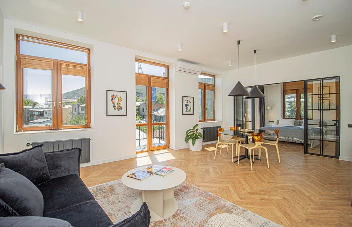 Bright and airy living space, where large windows flood the room with natural light, creating a warm and inviting atmosphere