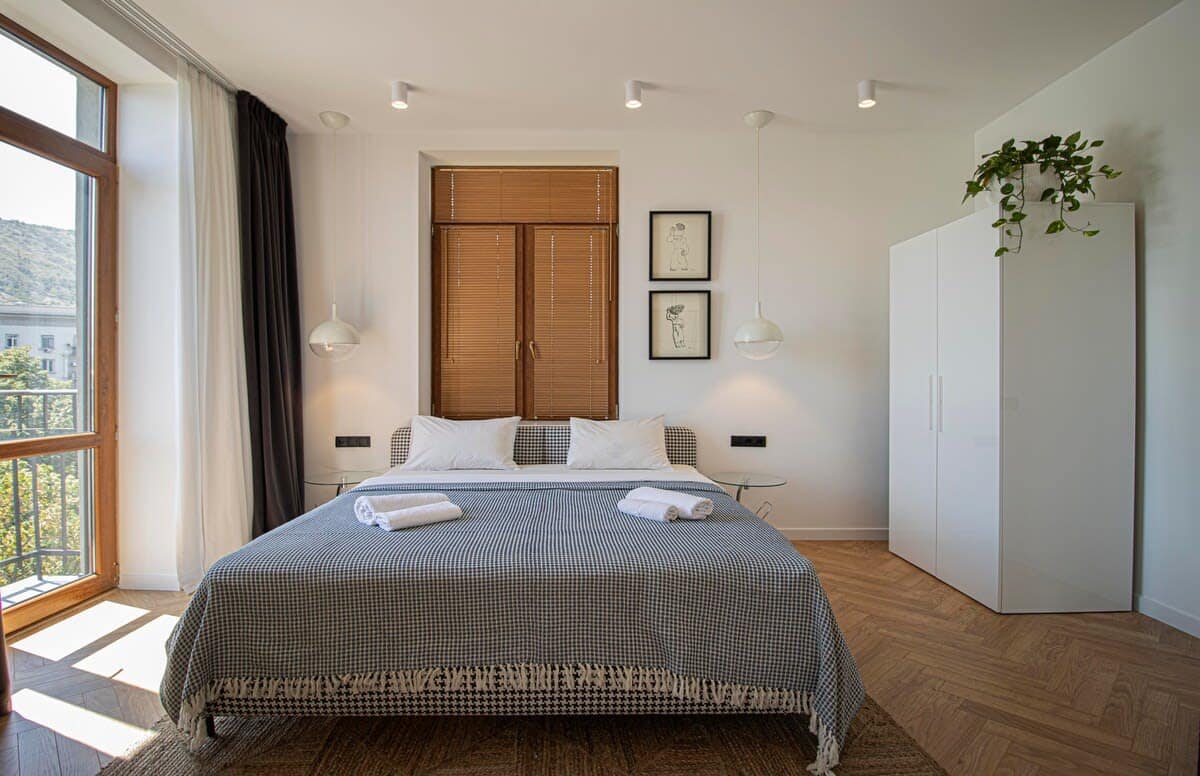 Step into a bright and inviting bedroom, where large windows flood the space with natural light