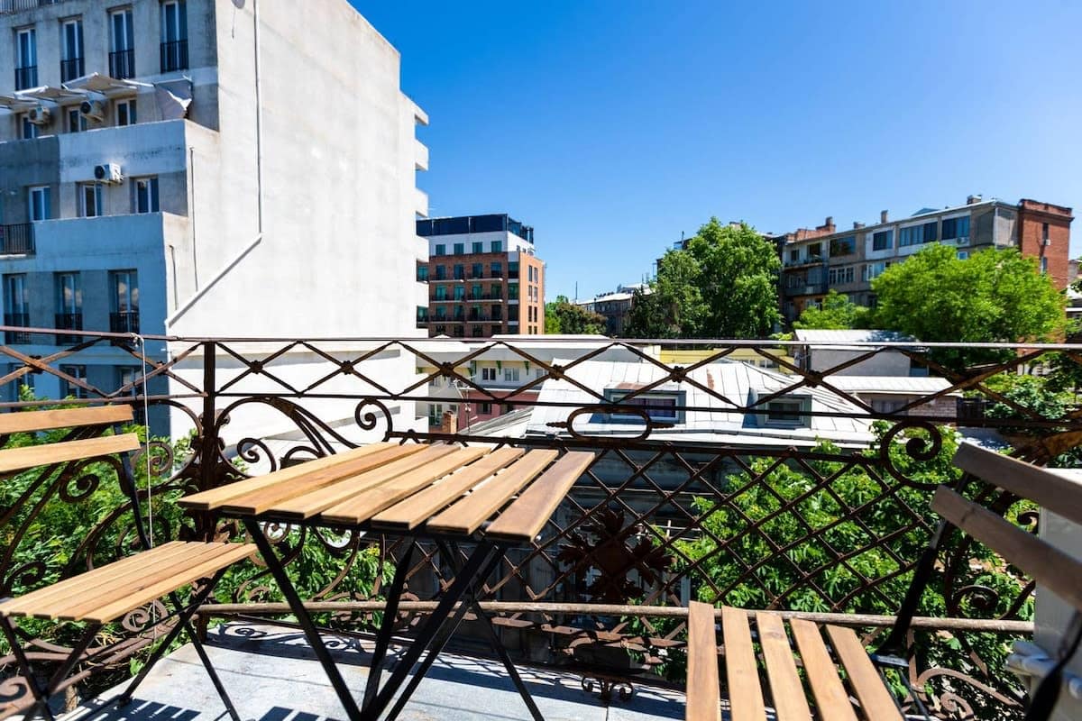 A lovely balcony with two cozy chairs and a table, perfect for enjoying the fresh morning air and soaking up the sunshine!