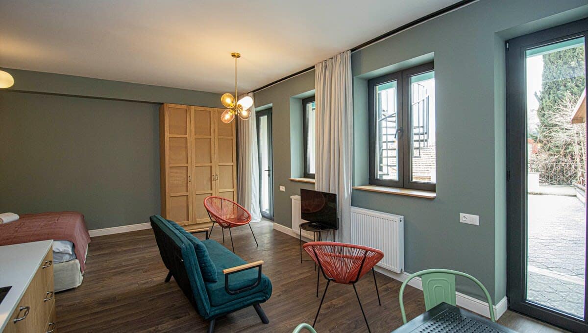 Functional and Stylish Decor – Earthy tones, wooden accents, and mid-century lighting give the space a trendy yet homely feel.