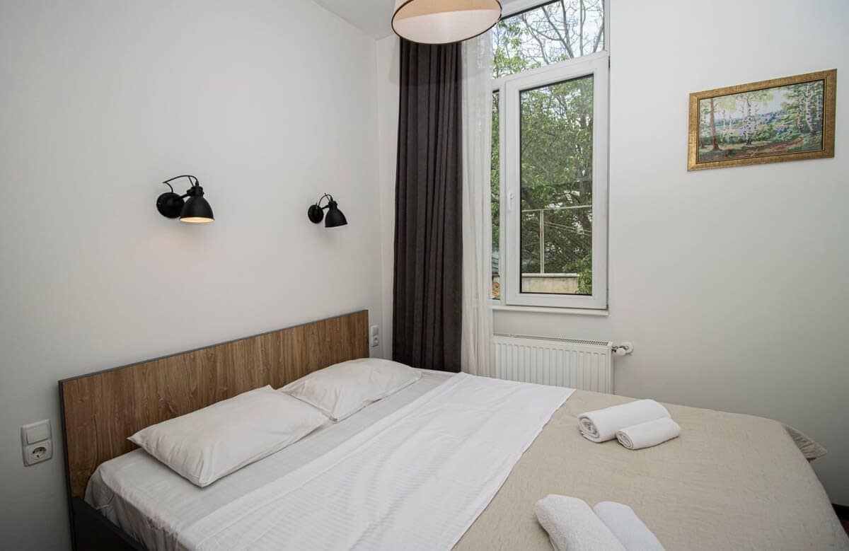 Comfortable double bed is dressed in crisp, fresh linens for a restful sleep