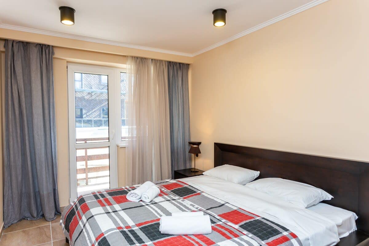 A bright and cheerful space with wooden nightstands and matching bed frames.