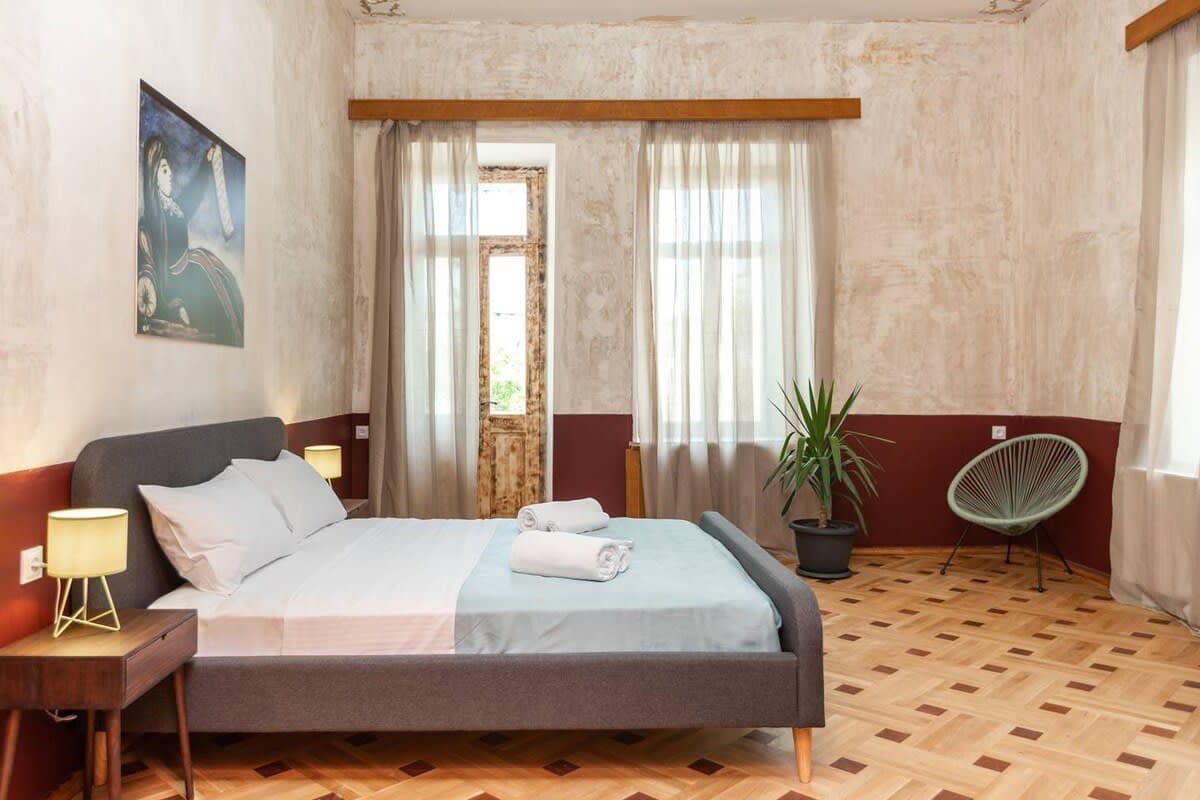 The multiple windows and access to the balcony enhance natural light, brightening the room.
