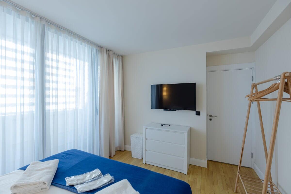 Modern TV is conveniently placed for entertainment, allowing you to relax and enjoy your favorite shows or movies right from bed