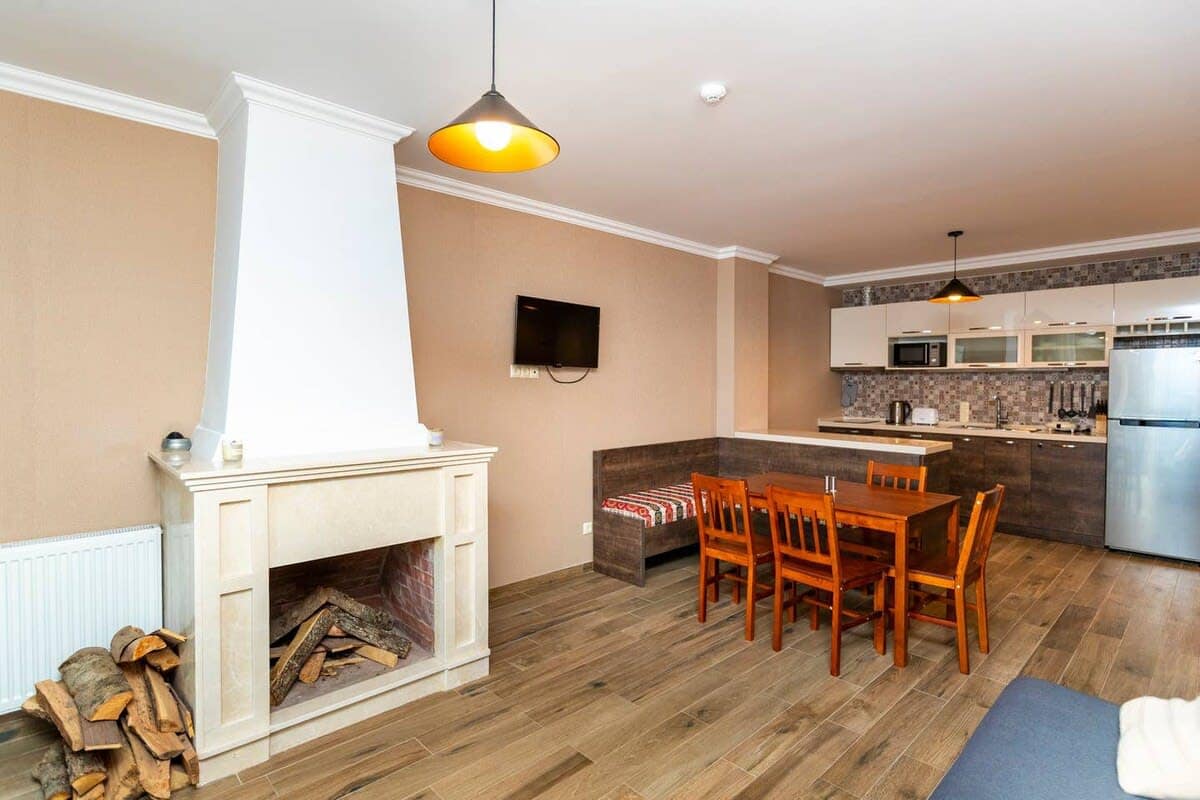 Enjoy the inviting living space with a fireplace, elegant wood elements, a dining table for 5-6, and lots of room to rest and recharge.