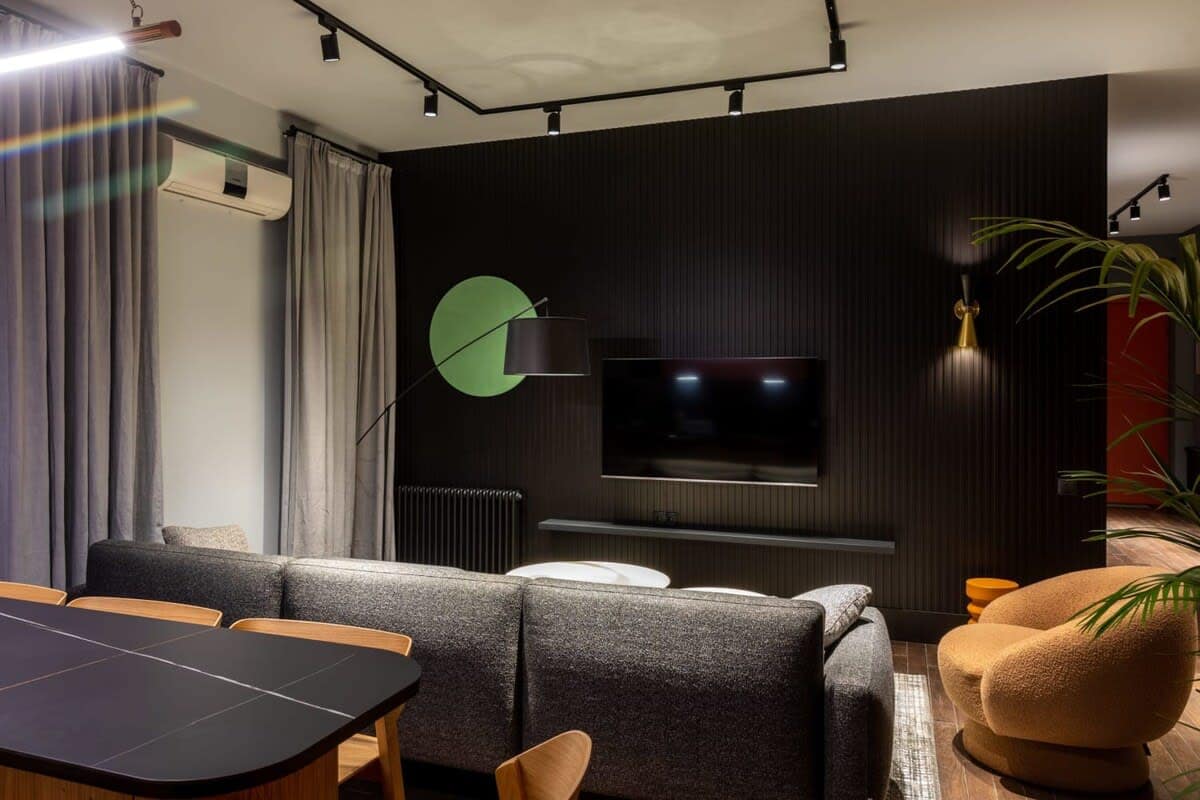 A comfortable seating area features a flat-screen TV set against a black background.