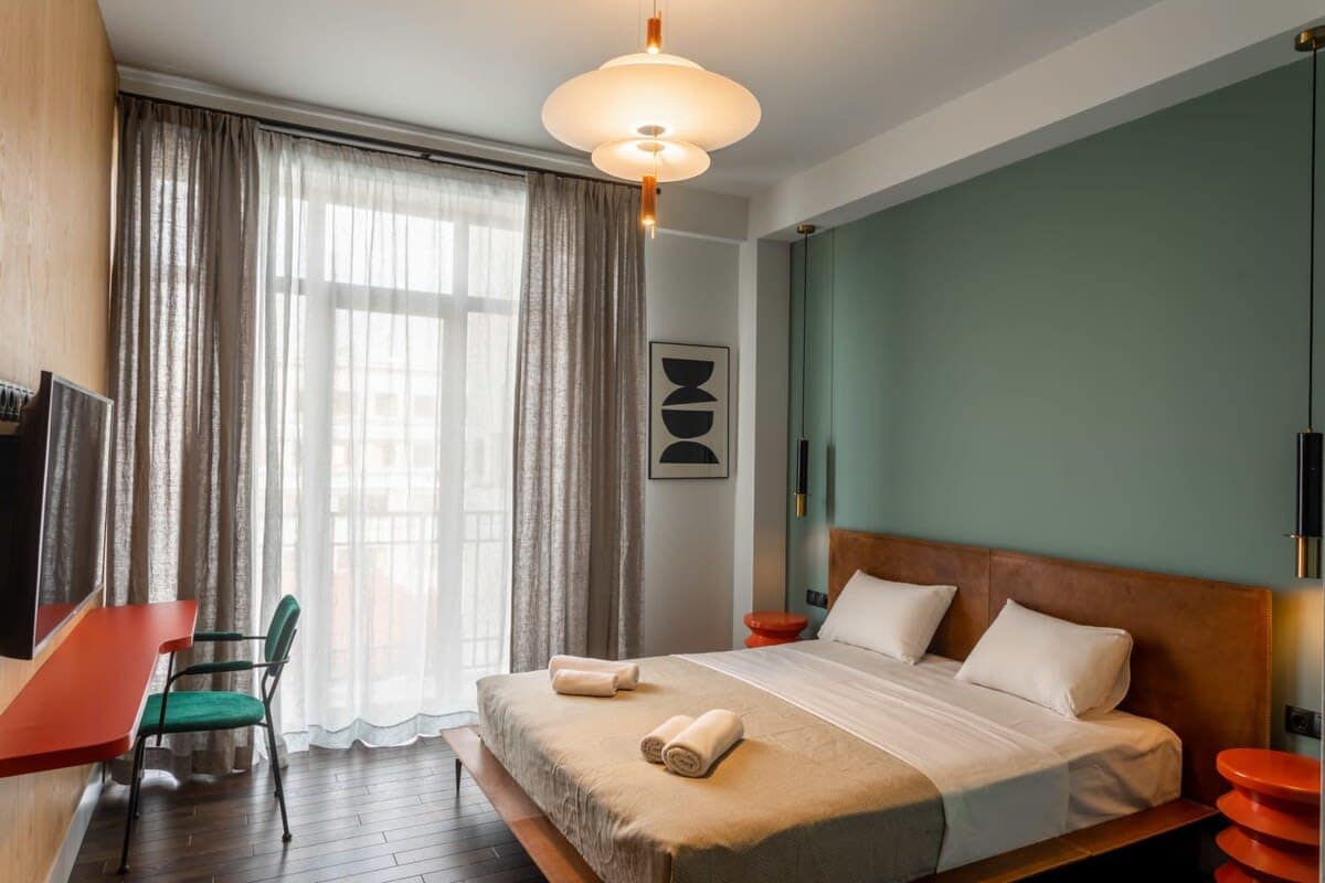 This bedroom offers multifunctionality with a TV and a dedicated workspace that is suitable for a laptop.