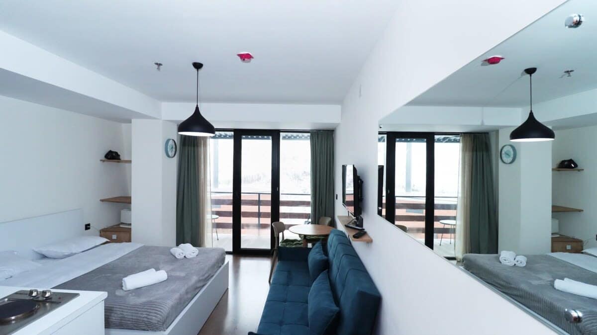 The open layout feels modern and clean, showcasing a comfy sofa in the main area.