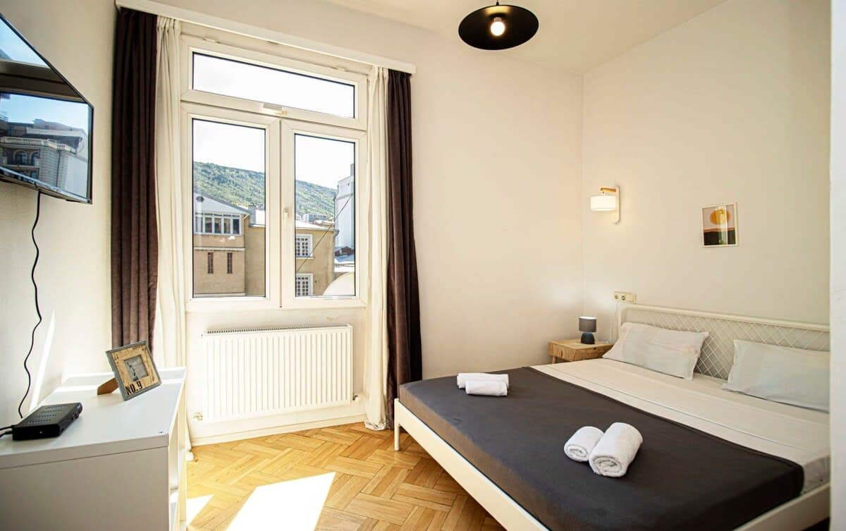Airy and well-lit bedroom is designed to offer a peaceful and comfortable atmosphere