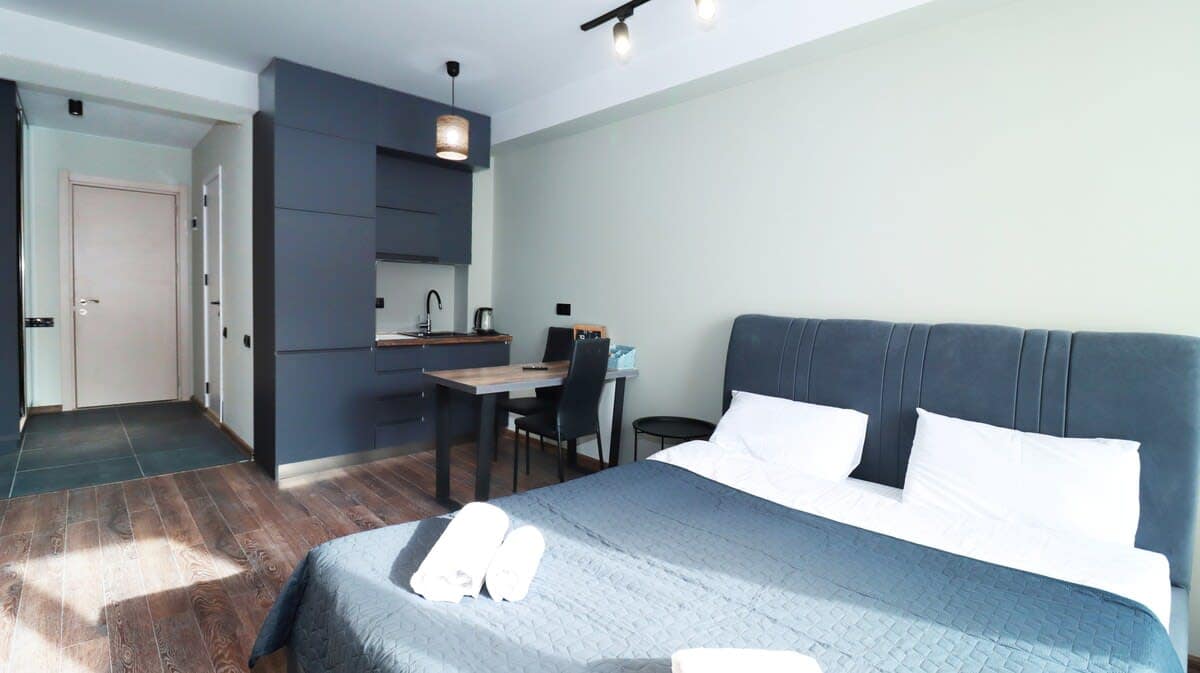 As you step into the apartment, you’ll find the cozy bathroom welcoming you on the left side, while a handy closet is just on the right. You’ll also discover the kitchen and a lovely dining table conveniently located on the left, perfect for enjoying
