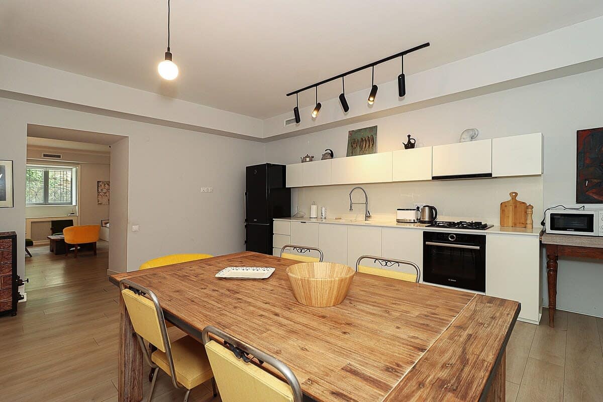 The dining area accommodates 5-6 people, and the dining table is positioned in front of the kitchen.