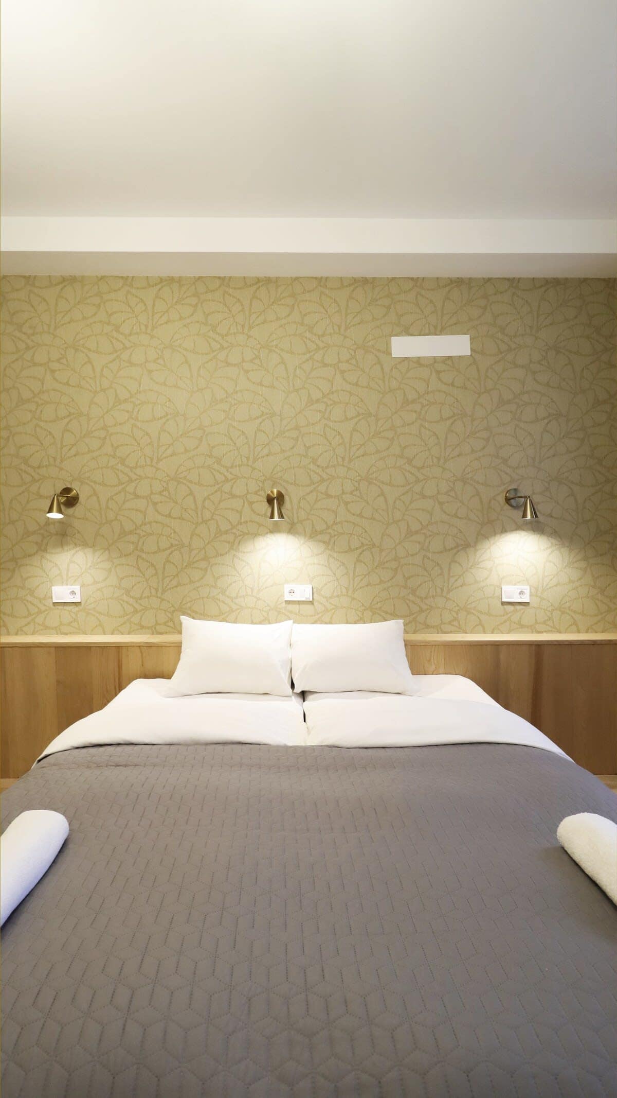 Soft lighting from the stylish bedside lamps enhances the cozy atmosphere of the room