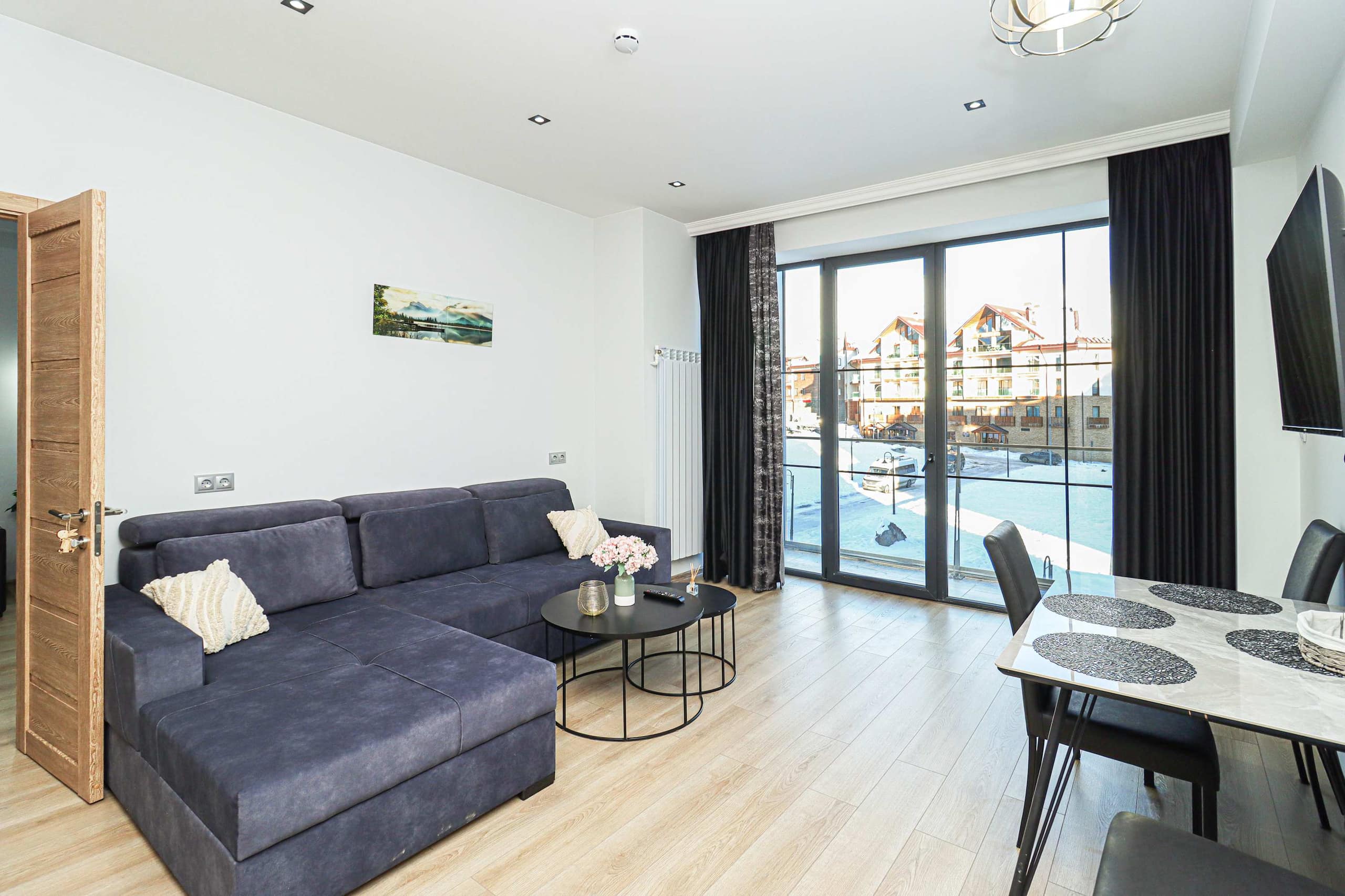 The living space includes a dining table and two coffee tables.
